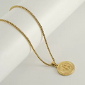 Gold necklace with a round pendant on a white background